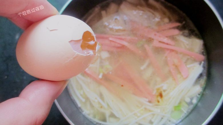 金针菇馓子汤,把火腿肠丝放入锅内，打入蛋液