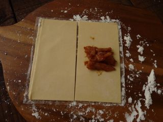 叉烧酥,
取酥皮对半切开，分别在酥皮的中间放下叉烧肉馅