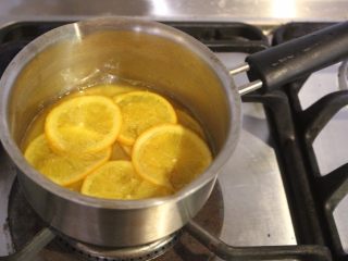 翻转柳橙蛋糕,煮约5分钟，稍稍收汁后熄火，柳橙片和剩余汁液放冷备用。