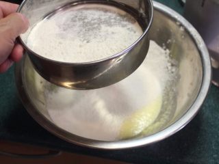 翻转柳橙蛋糕,将泡打粉和面粉混合，筛入蛋奶液中。