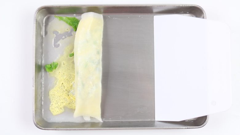 自制鸡蛋青菜肠粉,用刮刀从一边轻轻的卷起。