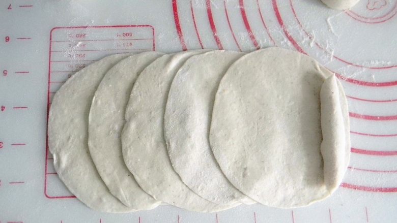 全麦玫瑰馒头,每每个面团擀成圆的薄饼状，五个一组，如图叠起来，最下面一端放一个搓成圆柱形的面剂子做花心