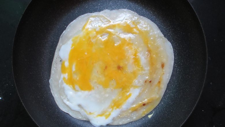 简易版的煎饼果子,把鸡蛋均匀摊在饼皮上