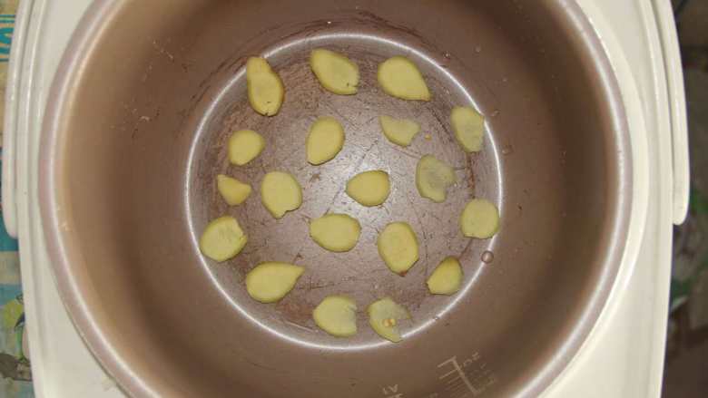 五花肉胡萝卜土豆焖饭,如图将姜片均匀铺在电饭煲底