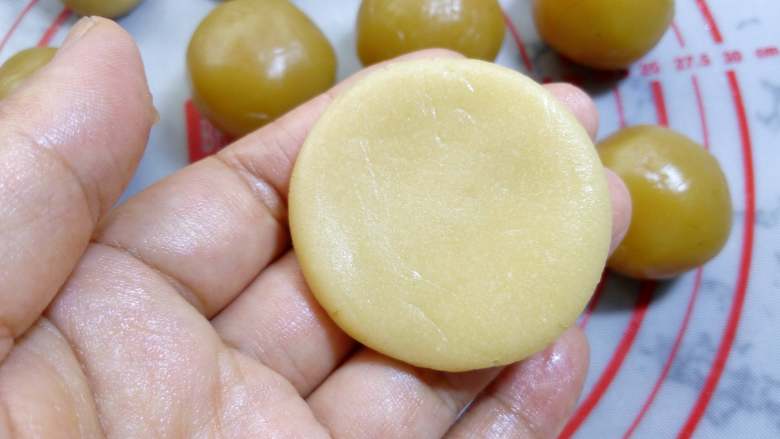 广式月饼~莲蓉蛋黄月饼, 饼皮在手中捏扁。