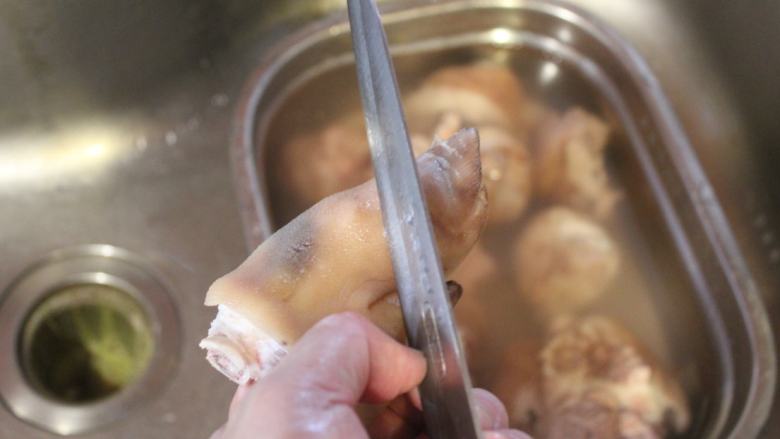 可乐炖猪脚,用刀将猪皮上的余毛和角质刮除干净。