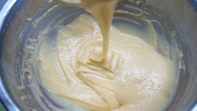 韩式豆沙裱花戚风蛋糕,以不规则的方向搅拌均匀，无干粉颗粒，提起打蛋器，蛋黄糊能比较顺畅呈丝带状垂落下来，放一旁静置备用；