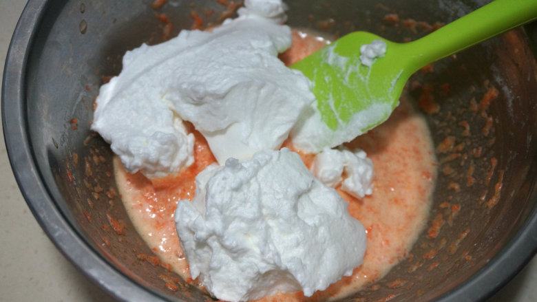 胡萝卜杏仁粉蛋糕,取1/3蛋白糊入胡萝卜杏仁粉糊中；此时烤箱可开始预热175度，上下火；