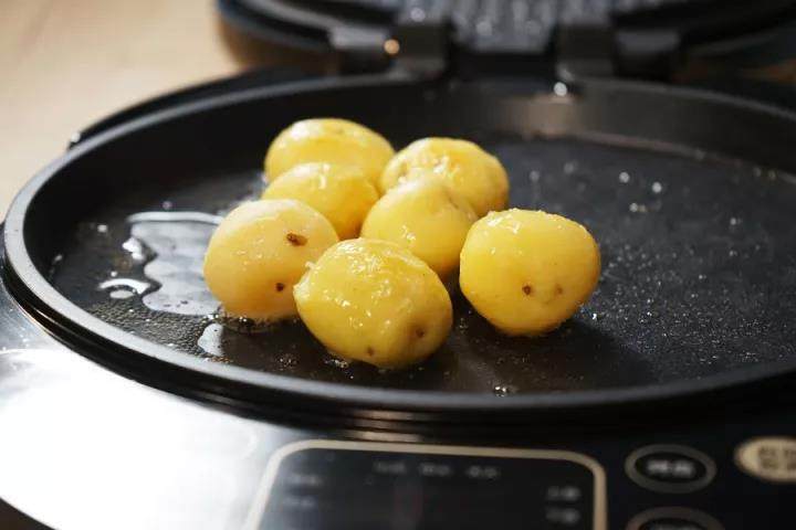法式煎牛排配迷你小土豆, 在电饼铛中放入适量的色拉油，小火煎制土豆5分钟。