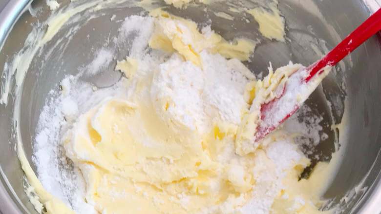 香酥曲奇花,将糖粉过筛后搅拌进软化的黄油中。