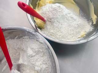 香酥曲奇花,低筋面粉和鹰粟粉混拌后过筛。将过筛后的粉类的一半加入到黄油中。