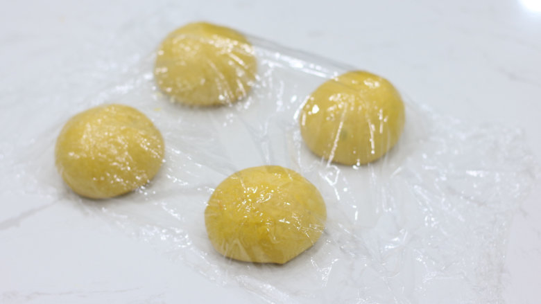 丰收的季节——金色南瓜吐司,平均分割为4个面团，滚圆后覆盖保鲜膜松弛20分钟。（也可以分成2份，做一卷的）