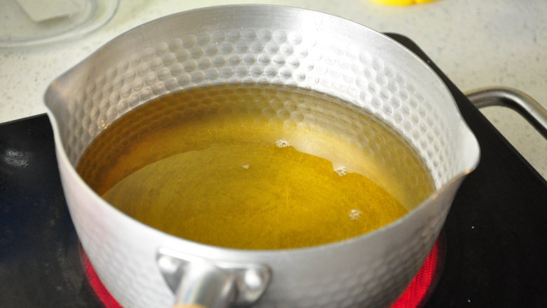 西班牙油条——吉拿果,油锅内的油加热至170度（丢一小块面糊能迅速浮起）。