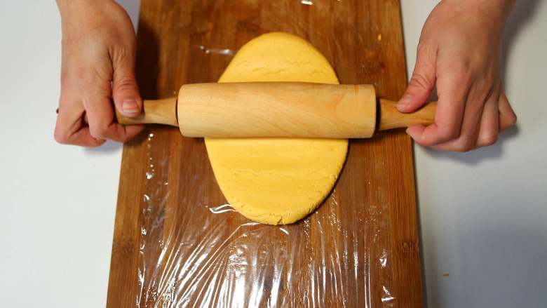 南瓜豆沙糯米卷,在案板上放一张保鲜膜,把面团擀成长方形