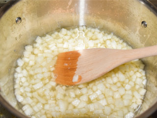 菊花雪梨酱,把梨倒入菊花水中，大火煮开，转小火慢慢熬煮，过程中要用长柄木勺不断搅动，防止粘底