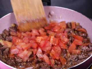 教你一个拌面的新吃法，口感爽滑劲道,将牛肉炒香后加入番茄丁下锅翻炒。