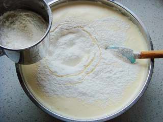 海绵蛋糕杯,先筛入一半的低筋面粉，翻拌均匀。