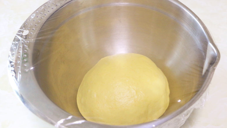 麻糍蜜豆萝卜餐包,将揉好的面团取出，放入一个干净的容器中，盖上保鲜膜，进行基础发酵1小时