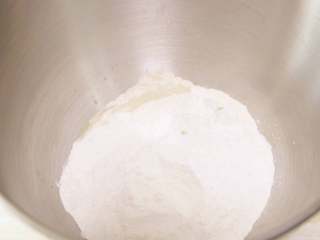 南瓜肉松芝麻包,把面团中除黄油之外的所有材料按照底层液体、中层粉类、上层干酵母的顺序全部放入厨师机桶里