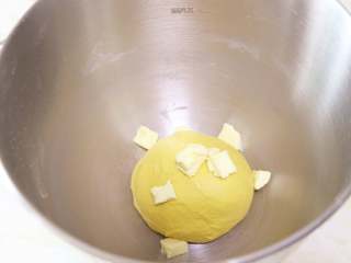 南瓜肉松芝麻包,启动厨师机揉面，待面团揉至光滑有韧性时，加入室温软化的黄油