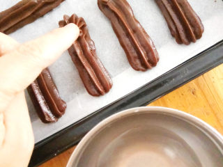巧克力手指泡芙,用手指沾一点清水，抚平泡芙末端翘起的角。