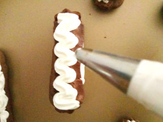 巧克力手指泡芙,在泡芙表面挤上奶油。