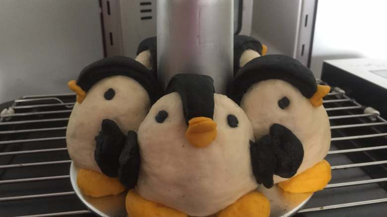 胖企鹅挤挤包,再抠出黄色、黑色的小圆片，做成嘴巴、眼睛，用水粘在发酵好的企鹅上