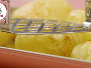 秘制迷迭香烤土豆,取出烤盘，将小土豆轻轻压扁