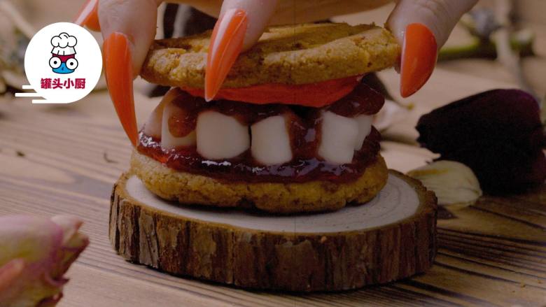 吸血鬼獠牙曲奇,在“牙齿”上抹上草莓酱，另一片曲奇上抹上奶油，组合在一起