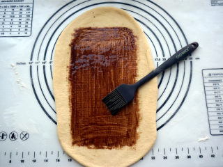 黑钻吐司,宽度确定后，往前后擀开，将面片擀薄，然后抹上一层巧克力酱。