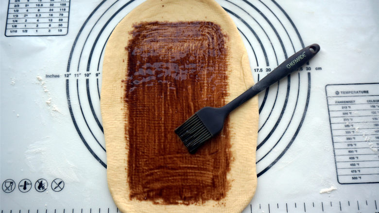 黑钻吐司,宽度确定后，往前后擀开，将面片擀薄，然后抹上一层巧克力酱。