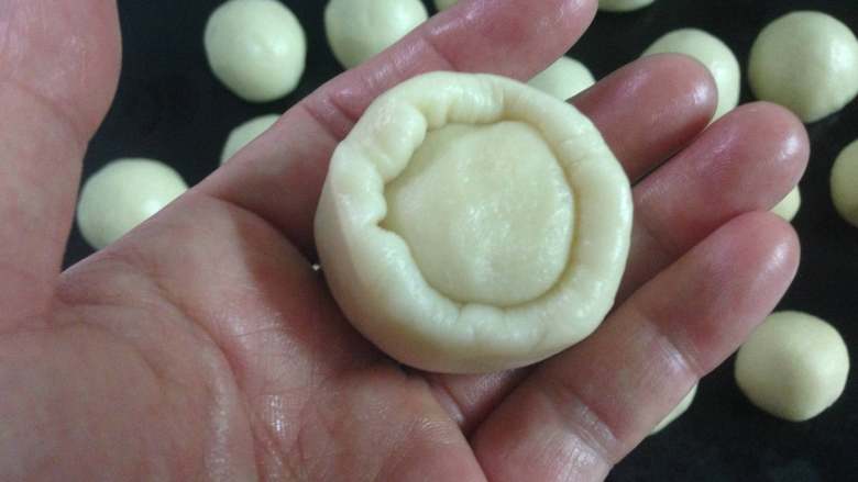 #中式点心#苏式鲜肉月饼,取一个油皮按扁，放入一个油酥。