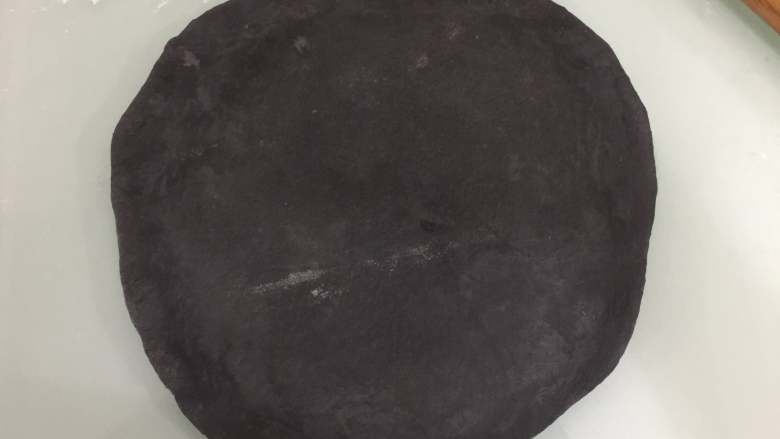 万圣节黑披萨,发酵后的面团压扁排气擀成圆片，要比披萨烤盘大一圈