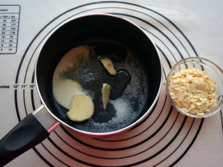 橘子酥塔,烘焙时间剩下5分钟时，开始制作焦糖牛轧糖。将淡奶油，淡味黄油，水怡，细砂糖放入奶锅中。
