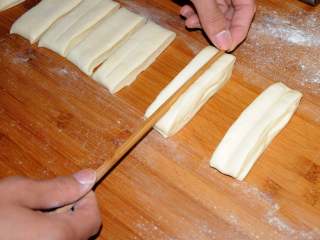 家常油条怎么炸 老师傅分享的方子 让你在家轻松做出好吃的油条,每两个条叠在一起，用筷子在中间压一下。