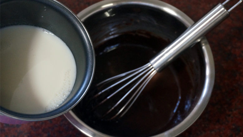 巧克力北海道戚风,将刚煮沸腾的牛奶倒入可可粉蛋黄面糊中，边倒边搅拌，然后将混合物过筛，重新倒入奶锅中。
