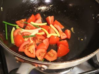 西红柿炒蛋,用原来的油锅，将西红柿和葱段下去翻煮。