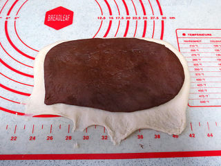 松软绵绵滴【可可双色面包】,翻面，将两种面团叠放在一起，压薄底边