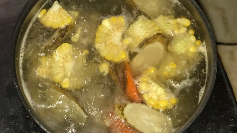 玉米胡萝卜牛蒡汤,汤水煲沸后熄火。