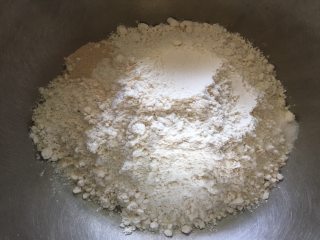 天然色素椰蓉花朵面包,将全麦面粉放入盆中，分别在两个角落加入酵母和食盐；