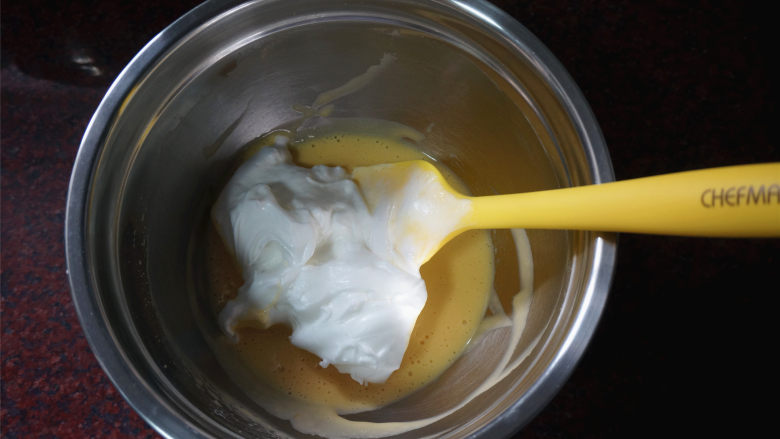 芒果花北海道戚风,将三分之一的蛋白糊与蛋黄糊切拌混合。