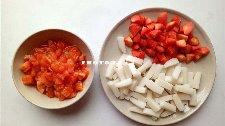 番茄年糕汤,胡萝卜去皮，切滚刀状；年糕切条状；番茄用开水烫1分钟，去皮，切丁；