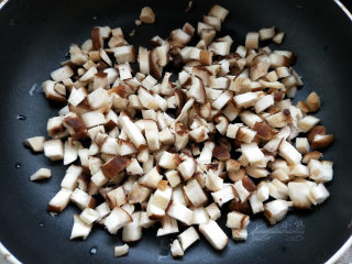 香菇青菜包子--不一样的做法,香菇也切成丁，放入锅内炒一下，不要放油。开始香菇会出些水，等水炒干了盛出来。
