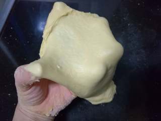 面包入门基本功之黄油面包卷,如此大约十多分钟后，面团逐渐均匀、细腻、光滑，可以撑开，但还没到手套膜的阶段。这一阶段的揉面需要十多分钟。