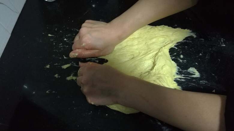 面包入门基本功之黄油面包卷,等操作台上看不太出黄油痕迹后，就可以继续采用未加黄油时的搓擦、摔打的方式来使面团起筋。