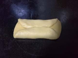 面包入门基本功之黄油面包卷,取出一个个小面团，先按扁，然后将较远端向下折三分之一，近端向上折三分之一。