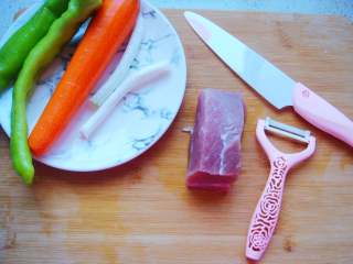 青椒炒肉丁,胡萝卜用刨刀刮去外皮备用。