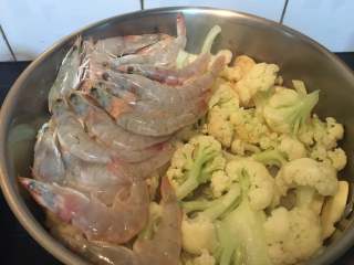 一锅出海鲜烩,焖3分钟后，开盖，在一边码上大虾。要平铺均匀。
