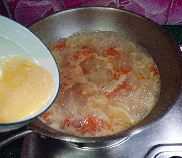#懒人料理#番茄鸡蛋疙瘩汤,接着将蛋液沿着锅边一圈倒入