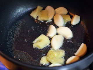 甜蜜滋味骨,待油温达到7成热，将蒜粒、生姜倒入锅内爆炒